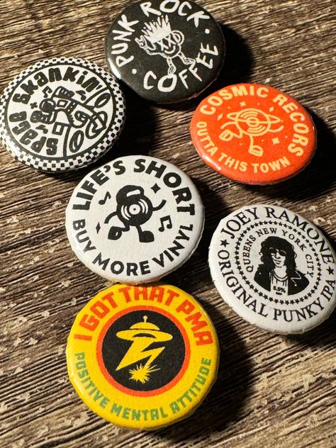 A collection of music inspired badges, based around my love for records and punk rock. Hand pressed by myself.  The pack includes:  * I got that PMA button badge (Bad Brains inspired) * Life's short buy more vinyl * Cosmic records  * Punk rock coffee * Space Skankin   * Joey Ramone original punky IPA * 25mm size * Metal badge case and plastic backer with pin  Free stickers with all orders. Design by: Jake Warrilow Punk Button Pins, Pins Design Button, Button Designs Ideas, Diy Pins Buttons, Button Pins Design, Button Pin Design Ideas, Button Badge Design, Pin Badge Design, Pin Button Design