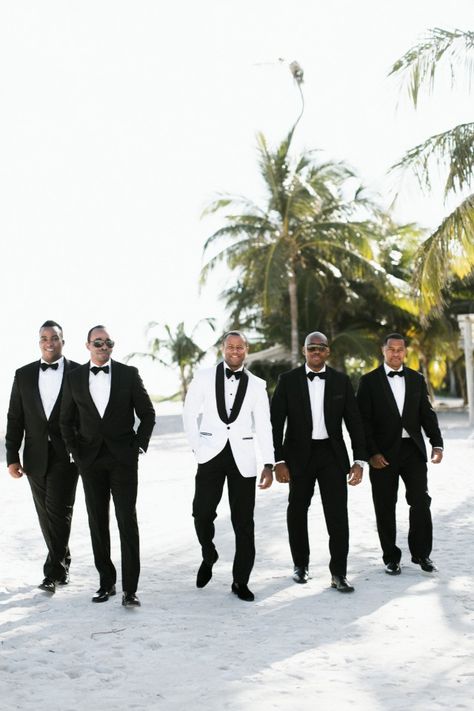 groomsmen in black and groom in white jacket Grooms In White Tuxedos, Black And White Tuxedo Wedding Groomsmen, White Groom Black Groomsmen, White And Black Groomsmen Attire, Bride And Groom In All White, Groom And Bride In White, Groom In White Jacket, Bride And Groom White Attire, Black And White Suit For Men Wedding