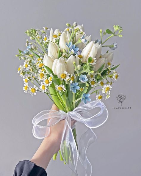 bouquet with white tulips, daisies, and blue flowers, all tied up with a tulle ribbon Daisies Aesthetic Bouquet, Aesthetic Tulip Bouquet, Bouquet Of Flowers Daisy, Daisy And Blue Flower Bouquet, White Tulip Flower Arrangements, Something Blue Bridal Bouquet, Spring Flowers Bouquet Tulip, Bouquet Of Tulips Wedding, Daisy And Blue Bouquet