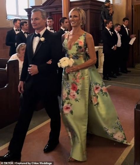 A mother-of-the bride has sparked fierce controversy online after wearing a flamboyant dress to her daughter's wedding. A video taken at the event with the caption 'The most stunning MOB dress we've ever seen!!!!' showed Lori DeWitt, 53, strutting down the aisle in her bespoke Audrey + Brooks outfit Romantic Mother Of The Bride Dresses, Elegant Mob Dresses, Audrey And Brooks Dress, Unusual Mother Of The Bride Dresses, Preppy Mother Of The Bride Dress, Mother Of The Bride Dresses Formal, Mother Of Bride Summer Wedding, Classic Mother Of The Groom Dresses, Mother Of The Bride Dresses Outdoor