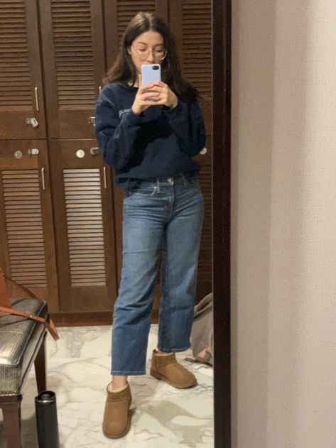 Young woman with dark hai and light skin takes a picture in front of a mirror. Wearing wide leg blue jeans, navy blue sweatshirt and chestnut color ultra mini Uggs. Ultra Mini Ugg Outfit Ideas, Ugg Ultra Mini Outfit Jeans, Ugg Mini Outfit Ideas, Outfits With Short Uggs, Short Uggs With Jeans, Ultra Mini Uggs Outfit Jeans, Mini Uggs Outfit Jeans, Ugh Mini Boots Outfit Jeans, Classic Ultra Mini Uggs Outfit