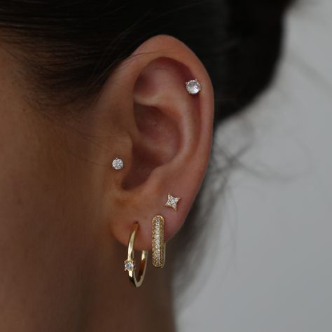 These stunning studs are a must in any jewelry collection! Spice up any stack with these babies or wear them alone for a timeless look. Studded Hoop Earrings, Ear Piercings For Small Ears Ideas, Three Lobe Earring Stack, Three Hole Earring Stack, 3 Stud Ear Piercing, Multiple Ear Piercings Minimalist Classy, 3 Hole Earring Stack, Earring Stack Studs, Earring Stack Inspo Gold