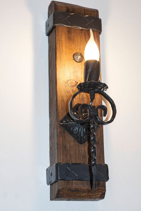 "Rustic wall light handmade made out of pine wood beam and wrought iron. Wood, iron and light combined is aesthetic and appropriate for many styles. Medieval lighting made using the best modern materials. Light will be made and shipped in a few days after you place your order. Beam is painted in dark lacquer. Iron is painted in hammered black. Easy fitting to wall with hangers mounted on back! Height is 50cm (20\"). may slightly vary. Can be installed in any country! 110/230V Comes with e14 bulb Medieval Lighting, Funky Lamps, Rustic Oak Furniture, Steampunk Furniture, Rustic Wall Lighting, Medieval Decor, Rustic Light Fixtures, Entrance Gates Design, Led Wall Art