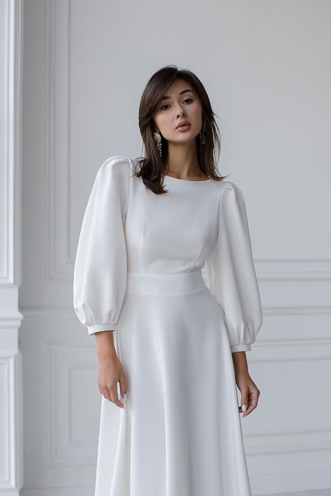 Captivate the room with the ELAGIA White Backless Puff Sleeve Midi Dress. The perfect fusion of sophistication and allure, featuring puff sleeves and a stunning backless design. #whitedress #backlessdress #puffsleeve #midi #ElagiaFashion #sophisticatedstyle #femininecharm #dressfashion #glamorouslook #etherealbeauty