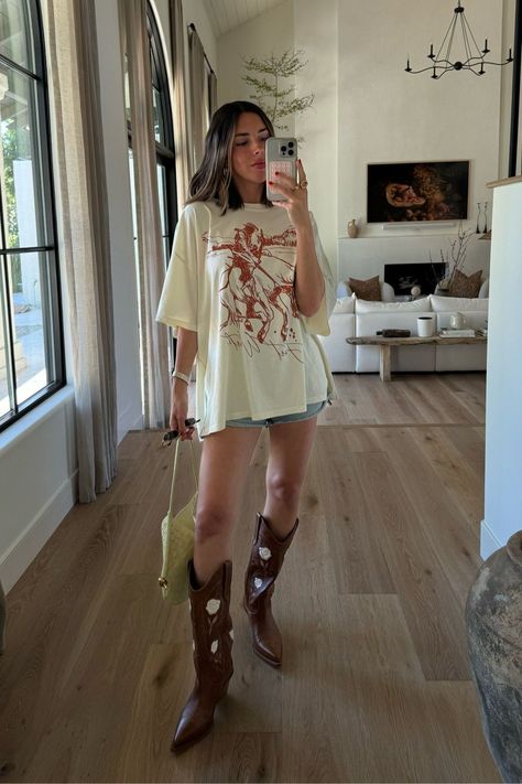 looking for more casual, western inspired outfits for summer? I've got you covered. tap to shop this oversized graphic tee, denim shorts, yellow shoulder bag and brown cowboy boots for summer and check out more of my everyday casual outfits for summer. Rock Cowboy Boots Outfit, Texas Summer Outfits, Cowboy Boots Outfit Summer, Casual Western Outfits, Traje Cowgirl, Western Inspired Outfits, Cowboy Boots Women Outfits, Country Concert Outfit Ideas, Summer Boots Outfit