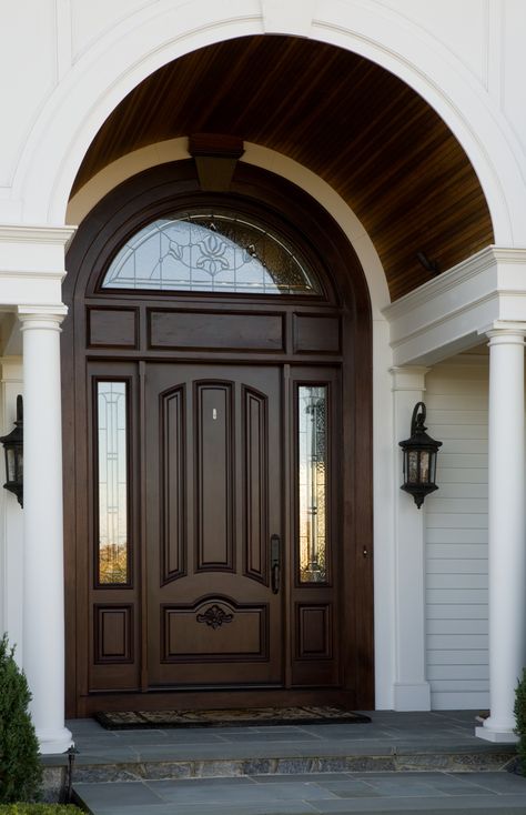 A beautiful wooden arch accentuates the curved window above the front entrance. Curved Door Design, Arch Window Above Front Door, Arch Top Front Door, Main Door Arch Design Entrance, Arch Main Door, Oval Front Door, Curved Ceiling, Curved Door, Oval Door