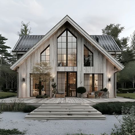 This image showcases a stunning split-level Scandinavian-style home featuring a classic gabled roof and modern design. The exterior is clad in weathered wood siding, complemented by large, floor-to-ceiling windows that flood the interior with natural light. A spacious wooden deck with steps leads to the entrance, surrounded by neatly maintained plants and minimalist outdoor furniture. This home combines rustic charm with contemporary elegance, nestled in a serene, forested landscape. Window Model Architecture, Twin Gable House Exterior, Front Porch With Gable, Two Peak House Exterior, Modern Scandinavian Architecture, Split Level Barndominium, Scandinavian Style Home Exterior, Wooden Houses Exterior, Nordic Cottage Exterior