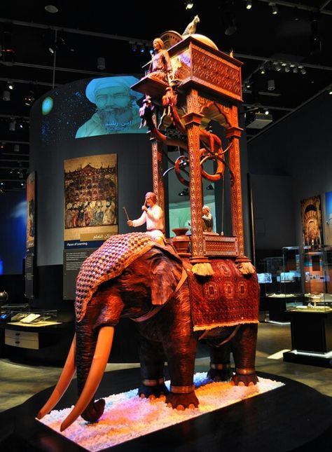 The Elephant Water Clock is an iconic example of one of al-Jazari’s pieces of fine technology. In addition to telling the time, it celebrates the universality of Islam by incorporating elements from Spain, Phoenicia, Egypt, Iraq, India and China Elephant Clock, Water Clock, Ben Kingsley, Museum Of Science, Marine Fish, Statue Sculpture, History Of Science, Telling Time, Futuristic Architecture