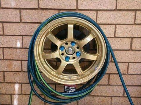 Repurposed Car tire rim hose holder Diy Car Projects, Garden Hose Storage, Car Parts Decor, Old Car Parts, Brick Edging, Car Part Furniture, Automotive Furniture, Hose Storage, Car Furniture