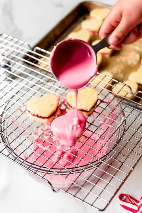 These Valentine's Day Petit Fours are the loveliest way to celebrate all things pink, red, and white this February 14th! They are bite-size white cake layered with raspberry jam jam and cut out in heart shapes then coated in a pourable fondant icing. #petitfours #ValentinesDay #holiday #fondant #icing #cake #mini #easy #recipe #hearts Pourable Fondant, Petit Four Icing, Petit Four Recipes, Cake Slicer, Giant Chocolate Chip Cookie, Jam Jam, Glaze For Cake, Fondant Recipe, All Things Pink