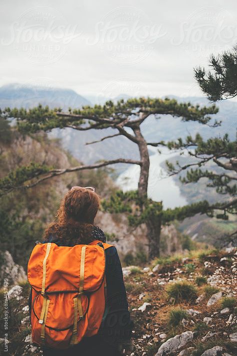 Woman with an orange backpack enjoying the view from a high mountain viewpoint. Green Trendy Outdoor Backpack, Green Outdoor Backpack, Cheap Yellow Outdoor Backpack, Red Hiking Backpack, Eco-friendly Outdoor Backpack, Orange Backpack, Woman Hiking, Orange Backpacks, High Mountain