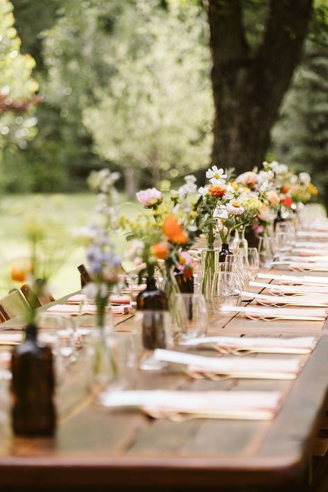 Colorful Spring Wedding Reception Decor | Whimsical, colorful outdoor wedding reception set up. The long table is beautifully decorated with vibrant flowers and set with peach-colored napkins. Discover whimsical wedding centerpiece, whimsical wedding color palette, mountain wedding colors and wedding reception aesthetic. Book Nina for your Colorado wedding or adventure elopement at larsenphoto.co! Farm Table Flowers Wedding, Simple Backyard Wedding Reception Decor, Long Wedding Table Ideas, Simplistic Outdoor Wedding, Farm Wedding Tables, River Wedding Reception, Farm Table Reception, Single Table Wedding Reception, Minimal Long Table Wedding Decor