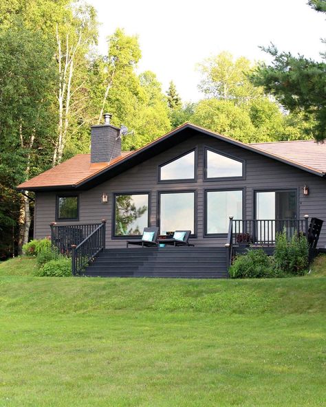 Dark house exterior with grey brown siding and black windows and soffit. Love the black deck and copper metal roof! Such a dark and moody house exterior, with sparkle! #darkhouseexterior #houseexterior #copperroof #blackwindows Lake House Exterior, Dark House Exterior, Copper Metal Roof, Lattice Deck, Behr Exterior Paint, Deck Skirting, Lake Houses Exterior, Black Deck, Brown Roof