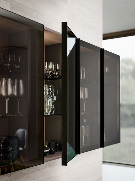 A finely crafted aluminium frame meticulously assembled with the glass panel creates an exclusive and refined accessory.

The new glass doors feature a smoked glass panel set in a black anodised aluminium frame with an integrated pull on one side running along the full height of the door.

The range of available modules provides glass door solutions for wall, base and tall units. Black Glass Cabinet, Luxury Room Design, Glass Kitchen Cabinets, Cabinet Glass Doors, Industrial Kitchen Design, Modern Kitchen Cabinets, Glass Cabinet Doors, Kitchen Room Design, Luxury Rooms