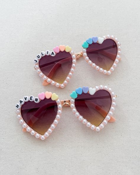 *because of the heart shape 6 LETTERS MAX is strongly suggested. if your little one has a longer name, consider using a shorter nickname or getting our round shape glasses! *each pair is decorated w/ name, hearts & faux pearls *makes great party favors! *fits most kids ages 3-10 *each pair is custom made and decorated to order. there may be slight variations than glasses pictured *WARNING - CHOKING HAZARD* Please handle sunglasses with care. This handmade item contains small parts that may becom Cheer Heart Glasses, Diy Heart Glasses, Heart Glasses With Beads, Decorating Sunglasses, Coquette Bday, Sunglasses Craft, Decorated Sunglasses, Pink Heart Sunglasses, Summer Gift Baskets