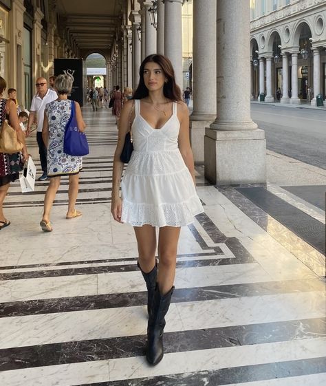 White Dress Black Boots Aesthetic, Short Dress Cowgirl Boots, Summer Dress Boots, Dresses With Boots Summer, White Mini Dress Black Boots, Mini Dress And Cowboy Boots Outfit, White Mini Dress Cowboy Boots, Dress Boots Outfit Summer, White Dress And Boots Country