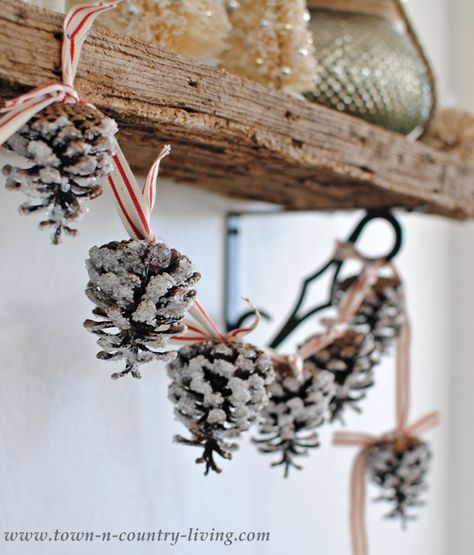 Frosted pine cones strung across a shelf will make any home feel like a cabin in the woods. Diy Christmas Tree Garland, Pine Cone Garland, Pinecone Crafts Christmas, Pine Cone Christmas Tree, Christmas Pine Cones, Diy Christmas Garland, Diy Pinecone, Cone Christmas Trees, Cones Crafts