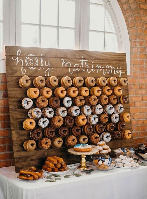 Holy Matrimony! Cute Donut Wedding Food Display and tons of other fun ideas for party food bars and dessert bars. | wedding reception dessert bar | Dessert Bar Wedding Reception, Reception Dessert Bar, Wedding Reception Desserts, Wedding Food Display, Party Food Bars, Reception Desserts, Wedding Donuts, Rustic Wedding Decorations, Donut Wall