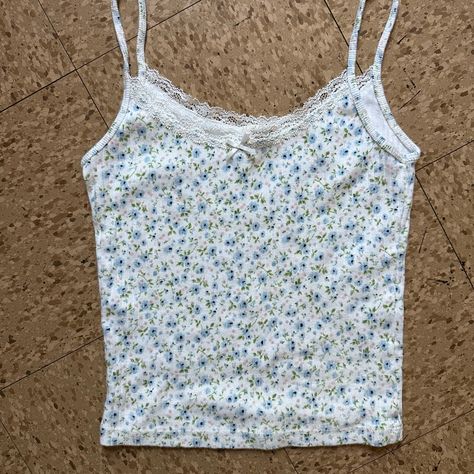 Fitted Cropped Spaghetti Strap Tank Top In White With Blue And Green Flowers, Lace Trimmings And A Bow. Fabrics: 100% Cotton Measurements: 17" Length, 11" Bust Made In: Italy Nwot Tank Top With Lace Trim, Blue Floral Tank Top, Brandy Melville Tops Tanks, Lace Tops Aesthetic, Brandy Tank Tops, Lace Tank Top Outfit, Aesthetic Tank Tops, Brandy Clothes, Coquette Tank Top