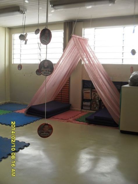 I like how the fabric is draped over the bar and suspended from the ceiling. It creates a cozy spot for a child to nap or relax away from other children. Preschool Rooms, Home Daycare, Sensory Room, Dekorasi Kamar Tidur, Book Corners, Classroom Setup, Classroom Design, Classroom Setting, Classroom Inspiration