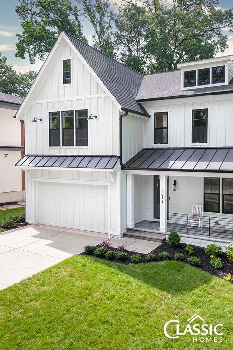 An exterior image of a white modern farmhouse of board and batten, half porch, black iron rails. Flagstone Front Porch, Maine Farmhouse, Barn Style Garage, Farmhouse Style Exterior, Farmhouse Craftsman, Hardie Board, Board And Batten Exterior, Exterior Of House, Spec Home