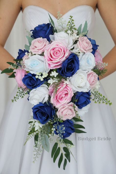 This lovely assortment of royal blue, pink and light pink roses is bound to turn heads on your wedding day. This lovely cascading brides’ bouquet from the is an absolutely breathtaking arrangement for any bride to be, in any season. Sage greenery and white accents complete the look and add a delicate realism to this beautiful bouquet. This bouquet is 10” wide, 18” long, and is crafted by our in-house florists without using a foam base to anchor the flowers to the bouquet. Instead, we wire our bo Royal Blue And Blush Pink Bouquet, Pink And Blue Wedding Flowers Floral Arrangements, Navy Blue Light Pink Wedding, Royal Blue And Blush Pink Wedding, Navy Blue And Light Pink Wedding Theme, Wedding Navy Blue And Pink, Wedding Ideas Pink And Blue, Royal Blue And Light Pink Wedding, Royal Blue And Light Pink Wedding Theme