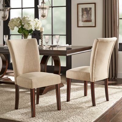 This set of upholstered dining chairs lends an eye-catching focal point in your dining room or kitchen. It arrives in a set of two and is crafted on a solid wood frame. It features linen upholstery on the seat and back in a solid neutral finish for a look that complements nearly any color palette in your traditional aesthetic. And its padded, foam-filled seat provides proper support for every meal. Main Color: Beige Linen | Three Posts™ Lancaster Upholstered Side chair Fabric in Brown, Size 38.0 Chair Silhouette, Grey Upholstered Dining Chairs, Parsons Chair, Wooden Dining Chairs, Wood Pedestal, Wayfair Furniture, Parsons Chairs, Wood Dining Chairs, Pedestal Dining Table