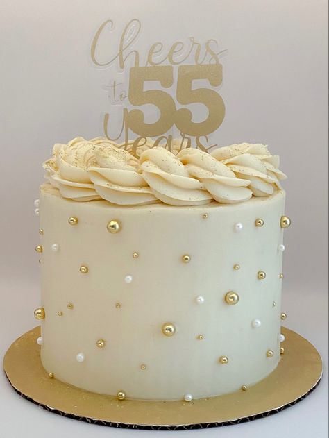 55th birthday cake with custom gold topper. Cream colored buttercream with piped ring on top with gold glitter and gold decorations Women’s Cake Ideas, White Golden Cake Design, White And Gold Cake Graduation, 50th Birthday Cake White And Gold, Birthday Cake 2 Tier Simple, 60yh Birthday Cake, White And Gold Cake 2 Tier, Golden Cakes Birthday, White And Gold Buttercream Cake