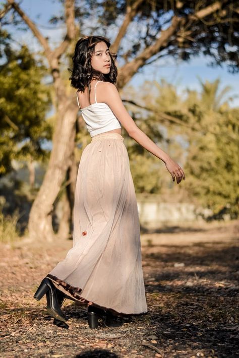 A Young Woman in a Long Skirt Looking over her Shoulder · Free Stock Photo How To Pose With Long Skirt, Long Skirt Pose Reference, Poses With Skirts Outfit Long, Full Picture Poses, Pose With Long Skirt, Poses With Long Skirt, Long Skirt Reference, Poses For Skirt Outfits, Long Skirt Photoshoot