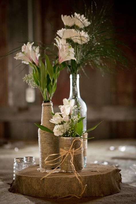 Diy Rustic Decor Wedding, Diy Wedding Centerpieces Wine Bottles, Light Up Wine Bottles Wedding Centerpiece, Glass Bottle Table Decor Wedding Ideas, Frosted Wine Bottle Centerpieces For Wedding, Wine And Beer Bottle Centerpieces, Flowers In Glass Bottles Centerpieces, Whisky Bottle Centerpiece, Glass Bottle Wedding Decor