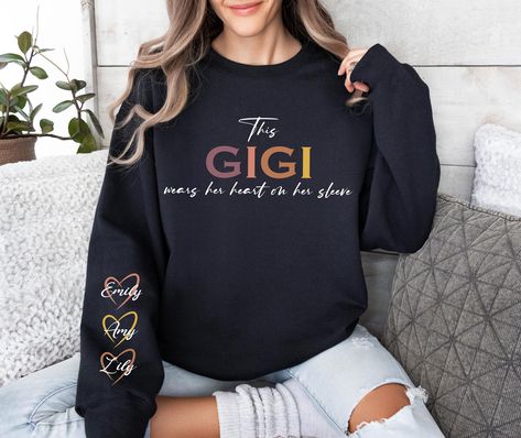 Custom Gigi Sweatshirt, Custom Grandma Gift, This Gigi Wears Her Heart On Her Sleeve Sweater, With Kids Name On Sleeve, Gigi Sweater, Gigi Gift HOW TO ORDER: 1. Please, Check and Review all Photos and Size Charts (All styles are Unisex) 2. Choose Your Color/Size  3. Choose Your Quantity as much as you want. 4. Click "Add To Cart". For multiple items go back to the listing and repeat the steps. *QUALITY: Sweatshirts (no hood) & Hoodies (with hoods), both styles are soft & comfy. They are UNISEX size, fitting men and women!  Sweatshirts/Hoodies are 50/50 cotton/polyester. * PROCESSING & SHIPPING: Processing time is 1-3 days. First Class Shipping is 2-5 business days (after processing time). You can upgrade your shipping on the checkout page to "UPS GROUND" or "UPS Air 2-Day" *CARE INSTRUCTIO Gifts For Gigi, Gigi Sweatshirt, Gigi Gift, Women Sweatshirts, Checkout Page, Grandma Gift, Size Charts, Sleeve Sweater, Add To Cart