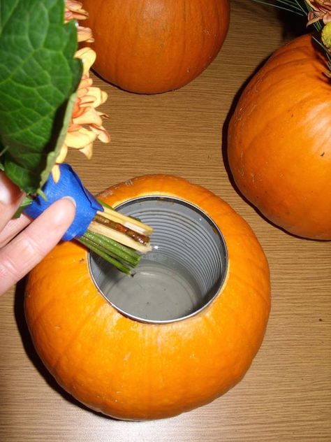 Carve out the center of a pumpkin, insert a soup can, and place flowers inside for an expensive looking (yet cheap) DIY fall centerpiece. Pumpkin Vase, Vase Diy, Pumpkin Flower, Dalian, Pumpkin Decor, Fall Party, Deco Floral, Fall Holidays, Fete Halloween