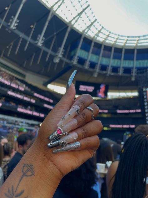 A picture of a left hand with a background of Beyoncé’s concert. The nails have unique styles with chrome French tips, gems and silver paint Beyonce Nail Art, Beyoncé Nails, Beyonce Nails, Nails Inspired, Glamorous Nails, Nail Files, Press Ons, Silver Nails, Coffin Nails Designs