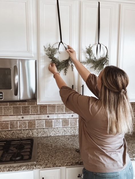 Hang Wreaths On Cabinets, Kitchen Cabinet Wreaths Christmas, Hanging Christmas Wreaths On Kitchen Cabinets, Caninet Wreaths, Mini Christmas Wreaths For Kitchen Cabinets, Wreaths On Kitchen Cabinets, Wreath Kitchen, Christmas Coffee Table Decor, Kitchen Wreath