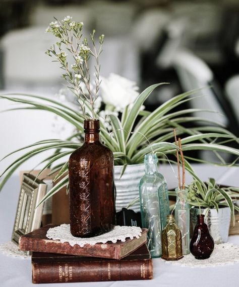 Small Bottle Centerpieces, Vintage Bottles Wedding Centerpieces, Antique Bottle Centerpieces Wedding, Vintage Book Wedding Decor, Antique Book Centerpieces, Spider Plant Centerpiece Wedding, Dried Floral Centerpieces Wedding, Antique Wedding Centerpieces, Books Centerpiece Wedding