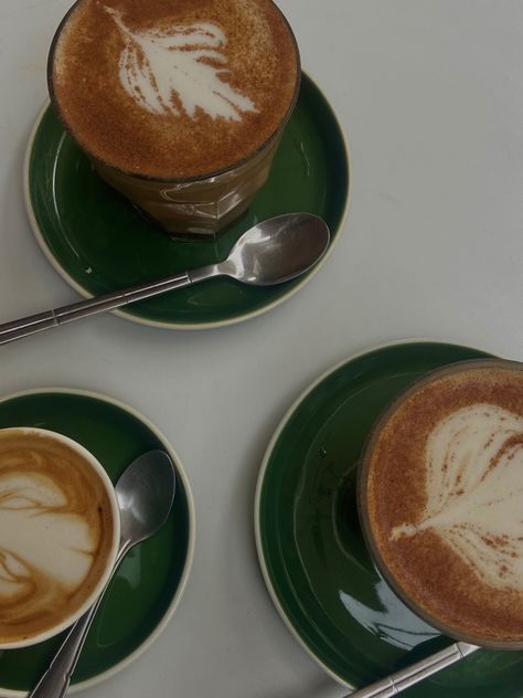 This image shows three emerald green saucers and mugs of coffee - two chai lattes and a macchiato Dark Green Coffee Shop, Fancy Coffee Aesthetic, Coffee Green Aesthetic, Coffee And Matcha Aesthetic, Dark Roast Coffee Aesthetic, Green Coffee Mug Aesthetic, Coffee Shop Branding, Fancy Coffee, Coffee Truck