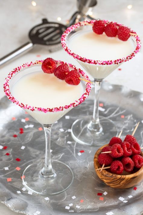 Two white chocolate cocktails in martini glasses and garnished with raspberries. Valentines Day Pitcher Drink, Vday Drinks Cocktail Recipes, Valentines Theme Cocktails, Valentines Martini Drink Recipes, Valentines Day Martini, Valentine's Day Cocktails, Valentine’s Day Martinis, February Esthetic, Vday Cocktails