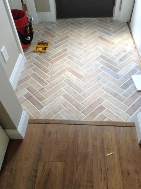 Herringbone Tile Entry, White Glazed Terracotta Tile, Brick Chevron Floor, Brick Slip Herringbone Fireplace, Entrance Ceramic Floor, Herringbone Tile Foyer, Herringbone Brick Floor Bathroom, Kitchen Living Room Flooring Transition, Small Entry Tile