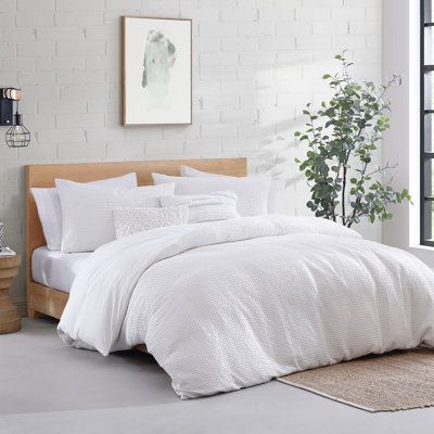 A comfortable and fashion-forward update for your bedroom can be done instantly with the DKNY Modern Waffle comforter set. Its cozy waffle texture in soft-washed cotton will envelop you in a cloud of comfort. In a crisp white color, this style will keep your bedroom dreamy. Color: White, Size: Queen | DKNY Modern Waffle 3 Piece Cotton Duvet Set Cotton in White | Queen | Wayfair | Home Decor Waffle Comforter, Textured Bedding, White Comforter, King Comforter Sets, Decor Pillows, Cotton Comforters, Throw Pillows Bed, Queen Comforter Sets, Queen Comforter