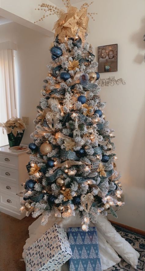 Blue/gold decorated Christmas tree . Blue and gold decor Flocked Christmas Trees Decorated Blue And Gold, Light And Dark Blue Christmas Tree, Blue Flocked Tree, Blue Silver Copper Christmas Tree, Christmas Tree Themes Colors Blue And Silver, Blue And White Christmas Trees Ideas, Blue And Rose Gold Christmas Decor, White Blue And Gold Christmas Tree, Blue Gold And White Christmas Decor