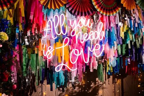 Fun Wedding Backdrop, Band Backdrop Wedding, Neon Backdrop Wedding, Backdrop With Neon Sign, Hanging Neon Sign Wedding, Barn Reception Decorations, Rainbow Floral Arch, Neon Sign Wedding Backdrop Flowers, Vibrant Disco Wedding