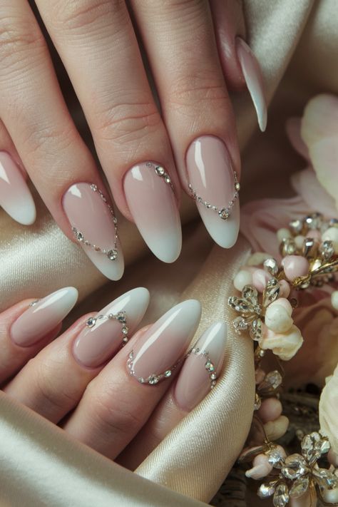 Elevate your nail game this season with these stunning almond nails adorned with delicate rhinestones. This chic design pairs perfectly with any outfit, making it a versatile choice for a night out or a casual day. The fusion of the almond shape with sparkling rhinestones creates a classy look that’s both pretty and edgy. Embrace this trendy style for Fall, and enjoy the fun of flaunting your nails! #AlmondNails #NailDesigns #NailInspo #TrendyNails Almond Shape Elegant Nails, Classy Gem Nails, Simple Gem Designs On Nails, Elegant Nails With Rhinestones, Winter Nails With Gems, Nails With Gems On Them, Nude Almond Nails With Rhinestones, Almond Nails With Bling, Almond Nails Gems