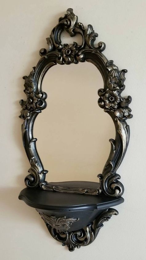 This mirror and shelf combo is beyond striking and a really nice size at almost 2 feet tall - it would make a phenomenal gallery wall centerpiece! 🖤DESCRIPTION: This is a vintage Dart mirror and shelf combo that has been painted a flat black and then distressed with European Gold metallic wax. The piece has been sealed with a clear coat. This is the perfect focal piece for that gallery wall or for your Victorian Gothic Room! 4th picture is with an adult male to give you an idea of size. **PLEAS Victorian Gothic Room, Gallery Wall Mirror, Wall Centerpiece, Black And Gold Frame, Gothic Mirror, Gothic Decor Bedroom, Mirror Shelf, Mirror Gallery, Gothic Room