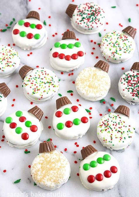 Oreo Ornaments – Oreo cookies dipped in white chocolate and decorated to look like a holiday ornament with peanut butter cup minis, and festive candies and sprinkles; stress-free Christmas cookie perfection. Oreo Ornaments, Cookies Dipped In White Chocolate, Oreo Sandwich, Oreo Cookies Dipped, Easy Christmas Treats, Christmas Candy Recipes, Christmas Foods, Peanut Butter Cup, Christmas Food Desserts