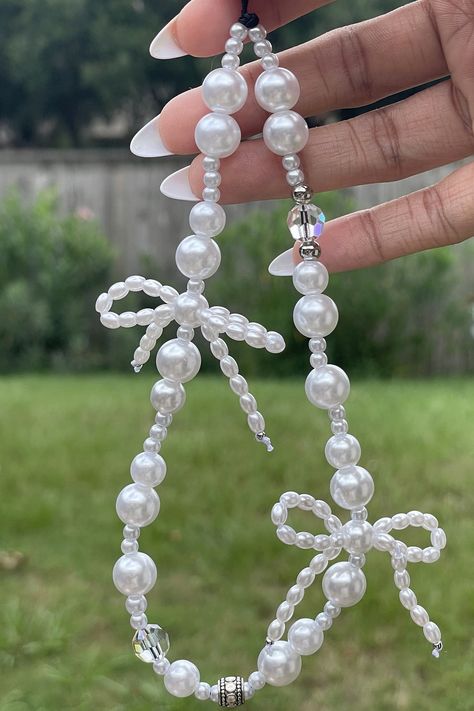 White bow phone charm  Made : Imitation pearls and Czech crystal beads White Phone Strap, Bow Phone Charm, Beaded Keychains Aesthetic, Craft With Beads, Beaded Phone Charms Aesthetic, White Phone Charm, Bow Beads, Pearl Phone Charm, Beads Phone Charms