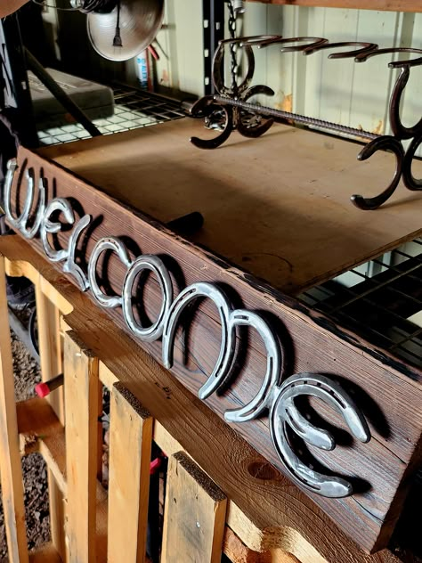 This handmade horseshoe welcome sign is a perfect addition to any country-style home décor. The sign is made of horseshoes and features a rustic pattern with a silver color. It measures 36 inches in length, 8 inches in height, and 2 inches in width, with a weight of 4 pounds. The sign can be hung on a wall, door, or fence, or placed on a shelf or table for added decorative effect. It is suitable for both indoor and outdoor use and is ready to hang. The sign is personalized with the option to pai Horseshoe Home Decor, Horse Shoes Crafts, Horseshoe Decorations, Horseshoe Letters, Rustic Pattern, Horseshoe Crafts Projects, Cutlery Art, Horseshoe Projects, Wedding Horseshoes