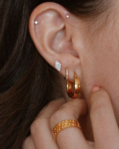 10 Piercings You Should Get Next Ear Piercings Forward Helix Triple, Gold Forward Helix Piercing, Helix And Forward Helix Piercing Chain, Tiny Ear Piercings, Forward Helix Piercing Hoop, Forward Helix Piercing Jewelry, Forward Helix Hoop, Curated Ear Piercing, Triple Ear Piercing