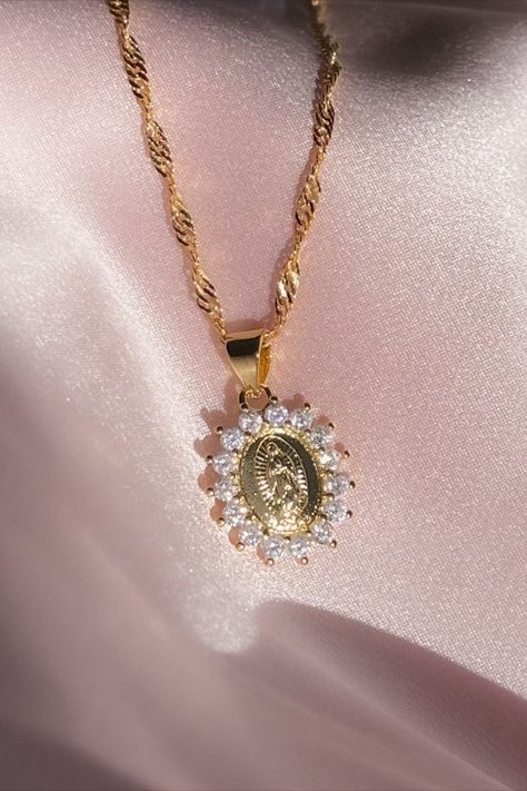 Embrace the grace and elegance of our Virgin Mary Necklace, a symbol of devotion. This exquisite piece features a radiant pendant in 18K gold plating over sterling silver, encircled by a ring of sparkling cubic zirconia stones. Inspired by faith and crafted with meticulous detail, this necklace embodies the perfect blend of spirituality and beauty. Elevate your style and carry the essence of faith with you. Shop now and adorn yourself with this exquisite Virgin Mary pendant! Mary Necklace, Catholic Necklace, Virgin Mary Necklace, Delicate Gold Necklace, Dragon Necklace, Lady Of Guadalupe, Medallion Necklace, Dragon Pendant, Jewelry Lookbook