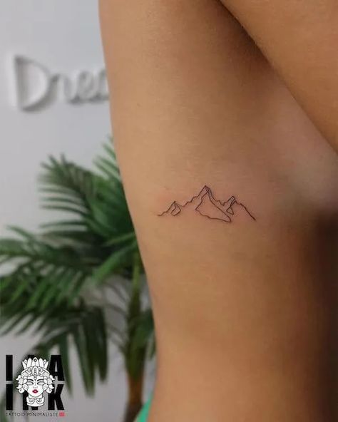 Discover 100+ minimalist tattoo ideas with meaning. Explore tattoo designs from minimalist animal tattoos, to geometric shapes, text-based ink, and more. Explore the art of minimalism today. Meaningful Mountain Tattoos, Mountain Tattoo Women Arm, Accountability Tattoo, Long Mountain Tattoo, Lake Louise Tattoo, Minimalist Outdoor Tattoo, Patagonia Tattoo Ideas, Nature Tattoos Minimalist, Run Tattoo For Women