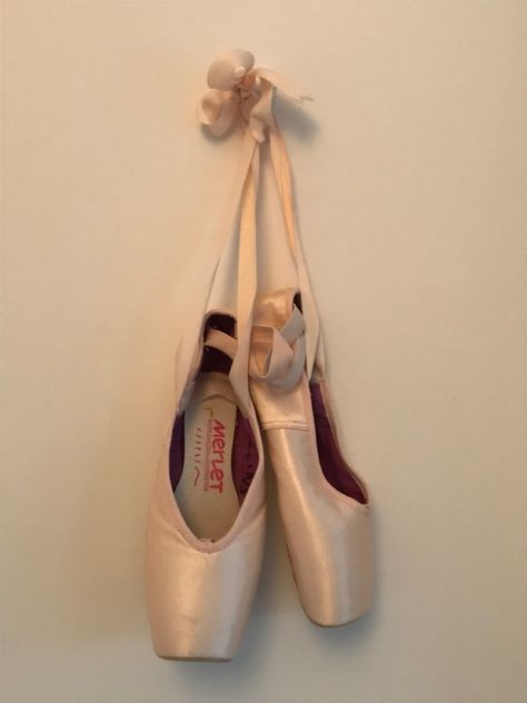 Pair of pointe shoes hanging on a white wall. Old Pointe Shoes Display, Pretty Pointe Shoes, Point Shoes Aesthetic, Ballet Brochure, Pointe Shoes Aesthetic, First Pointe Shoes, Pointe Shoes Photography, Ballerina Pointe Shoes, Point Shoe